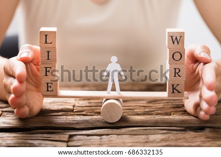 Close-up Of A Human Hand Protecting Balance Between Life And Work On Seesaw