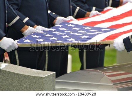 Horizontal photo of honor guard holding flag over casket at Arlington ...