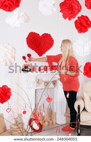 Woman decorates the house on Valentine's Day