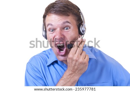 Hot tempered angry Caucasian man wearing blue collared shirt and communications headset holds mic and yells furiously on white background