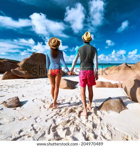 https://thumb7.shutterstock.com/display_pic_with_logo/52292/204970489/stock-photo-couple-on-a-tropical-beach-at-seychelles-wearing-rash-guard-204970489.jpg