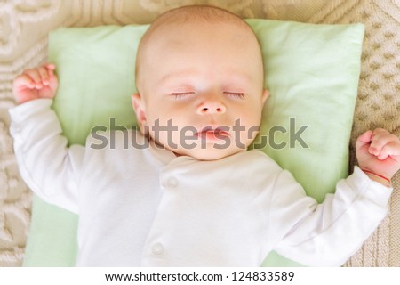 Cute newborn baby sleeping in bed on pillow