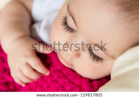 Closeup portrait of sleeping baby covered with knitted blanket