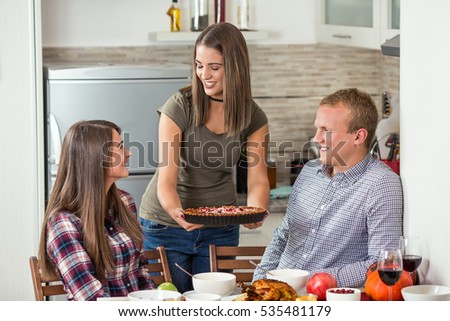 https://thumb7.shutterstock.com/display_pic_with_logo/530809/535481179/stock-photo-group-of-young-friends-is-having-a-dinner-party-proud-young-woman-is-serving-pumpkin-pie-she-made-535481179.jpg