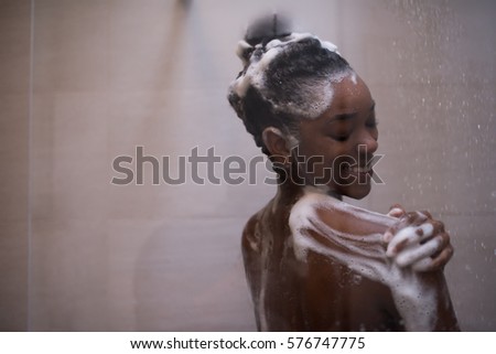 Woman in the shower,beautiful black young female showering under refreshing water, healthy lifestyle, enjoying time in luxury spa resort