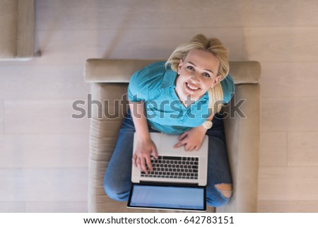 Young woman using her laptop computer in her luxury modern home top view