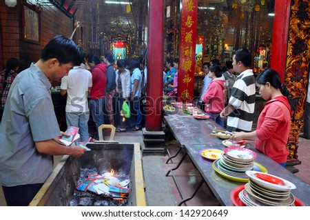 CAN THO - FEB 17: Unidentified believers offering food and incense sticks for the Gods in the Vietnamese Ong Buddhist temple. On February 17, 2013, in Can Tho, Mekong Delta, Vietnam