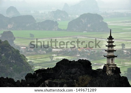 Landscape with limestone towers and rice fields in a rainy, cloudy day. Ninh Binh, Vietnam