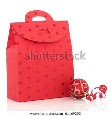 Christmas luxury gift bag and red and gold sparkling bauble with ribbon, isolated over white background.