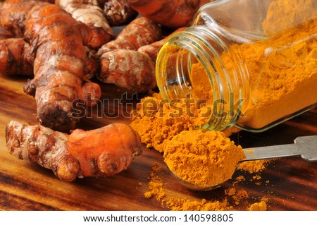 Fresh turmeric root, and ground spice - shallow depth of field