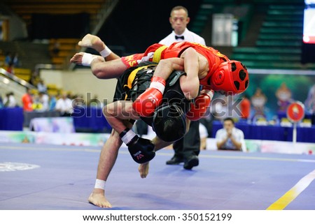 JAKARTA, INDONESIA - NOVEMBER 16, 2015: Mohsen Mohammadseifi of Iran (red) fights Van Tai Nguyen of Vietnam (black) in the men's 70kg Sanda event at the 13th World Wushu Championship 2015.