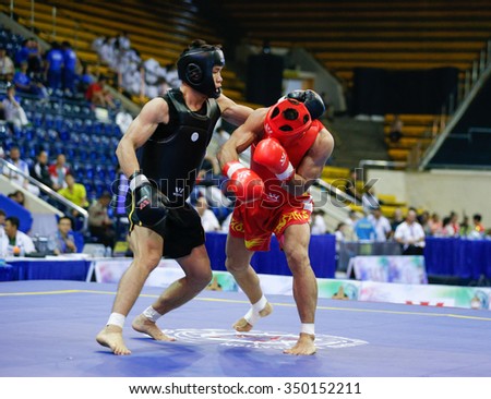 JAKARTA, INDONESIA - NOVEMBER 16, 2015: Mohsen Mohammadseifi of Iran (red) fights Van Tai Nguyen of Vietnam (black) in the men's 70kg Sanda event at the 13th World Wushu Championship 2015.