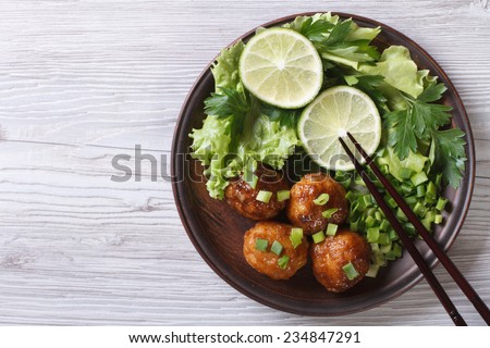 Fish balls in curry sauce on a plate with fresh herbs. top view of a horizontal