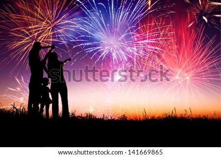 happy family standing on the hill and watching the fireworks