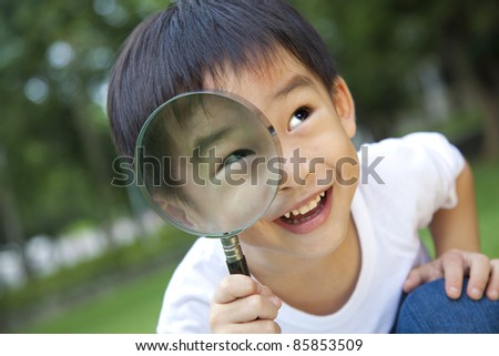 asian boy holding magnifier