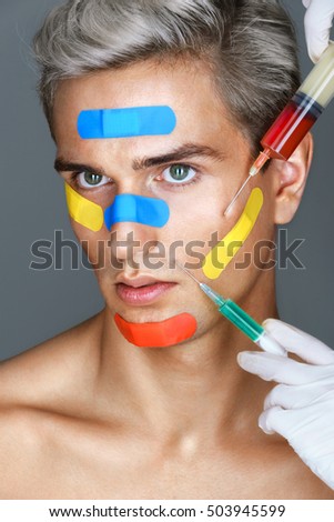 Attractive man with color patches on the face. Photo of Man having a botox injections. Beauty concept