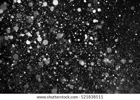 Falling snow on black background.