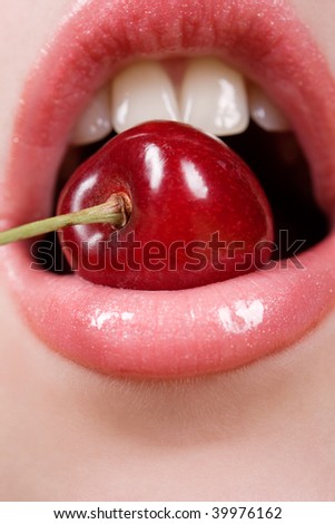 Woman mouth with lips and tongue eating cherry Stock Photo 
