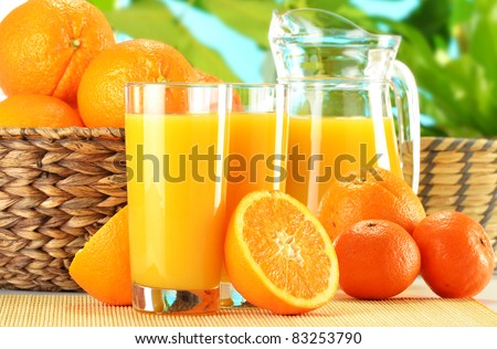 Composition with two glasses of orange juice, fruits and pitcher