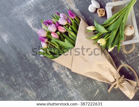 bouquet of tulips in a paper wrapper on wooden background