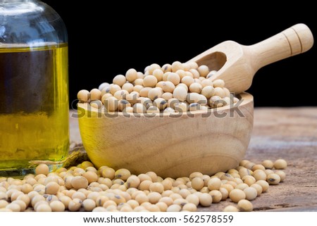 Soy bean and soy oil on wooden table.