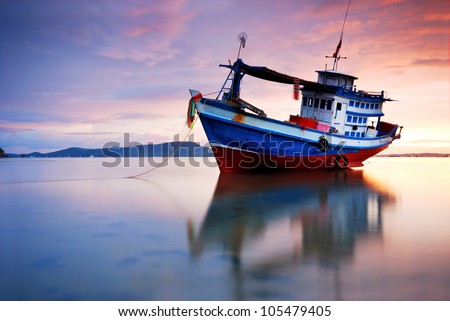 Thai fishing boat used as a vehicle for finding fish in the sea.at sunset