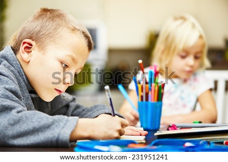 Siblings are doing his homework for elementary school.
