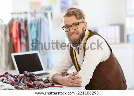Smiling fashion designer working in studio