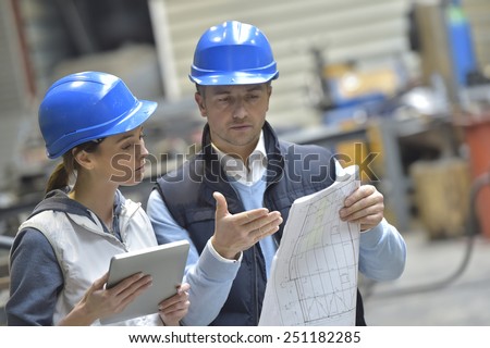 Engineers in mechanical factory reading instructions