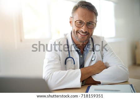 Portrait of mature, doctor sitting in medical office