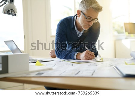 Portrait of architect in office working on blueprints