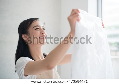 young woman holding clean laundry