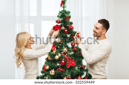 family x mas winter holidays and people concept happy couple decorating christmas - People Decorating A Christmas Tree family x mas winter holidays and people concept happy couple decorating christmas - People Decorating A Christmas Tree