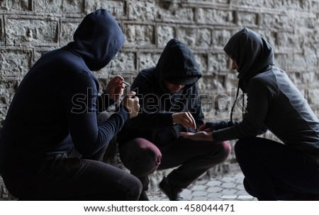 substance abuse, addiction and bad habits concept - close up of young people smoking cigarettes and using drugs outdoors