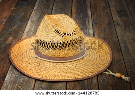 straw hat on wooden table - stock photo
