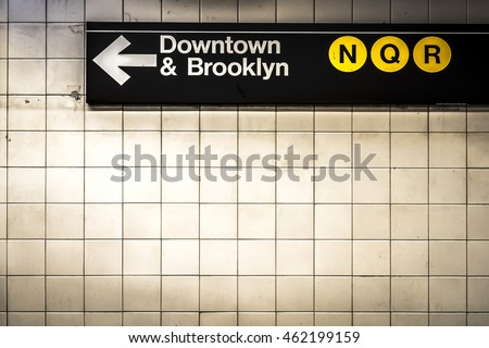 Subway sign in Manhattan directing passengers and travelers to the downtown and Brooklyn trains