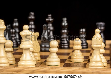 Wooden chess pieces on a game board ready to play