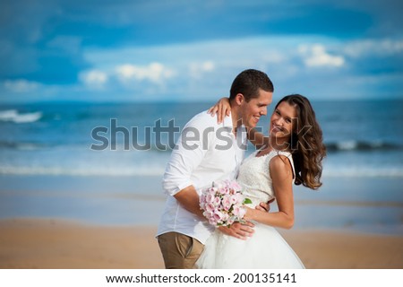 https://thumb7.shutterstock.com/display_pic_with_logo/659407/200135141/stock-photo-gorgeous-bride-in-a-wedding-dress-and-a-handsome-groom-getting-married-at-a-beautiful-beach-200135141.jpg
