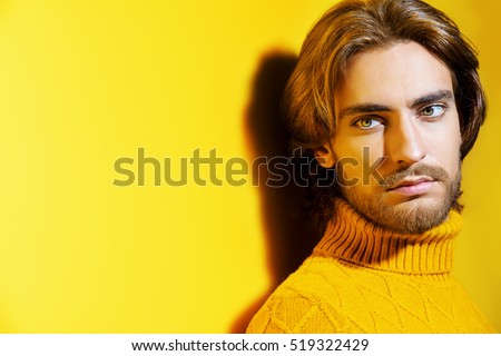Handsome man wearing yellow pullover. Men's beauty, fashion. Hairstyle for men. Yellow background.