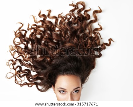 curly hair and part of woman'?s face, looking at the camera