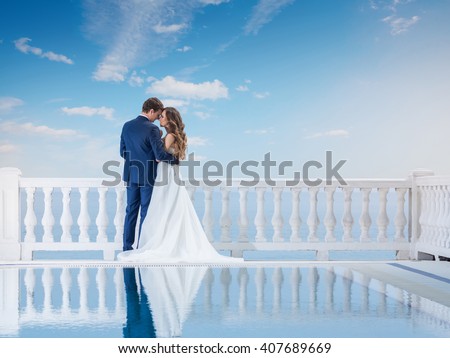 https://thumb7.shutterstock.com/display_pic_with_logo/682255/407689669/stock-photo-wedding-couple-hugging-and-standing-with-her-back-outdoors-near-the-pool-happy-bride-and-groom-in-407689669.jpg