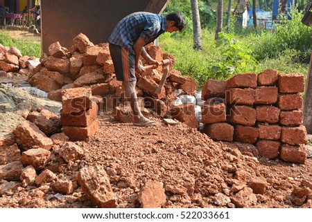 stock-photo-goa-india-november-man-breaks-stones-with-a-pickax-on-the-road-in-arpora-522033661.jpg