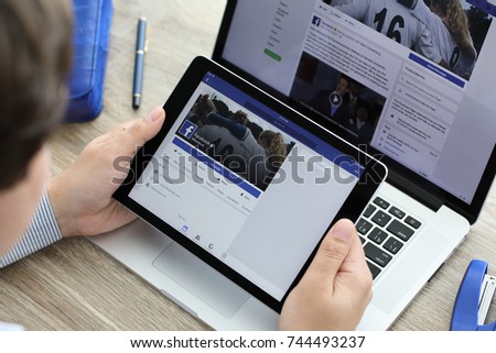 Alushta, Russia - June 7, 2017: Man holding iPad Pro and MacBook with social networking service Facebook on the screen. iPad Pro and MacBook was created and developed by the Apple inc.
