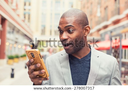 Young man using smart phone. Businessman holding mobile smartphone using app texting sms message wearing jacket