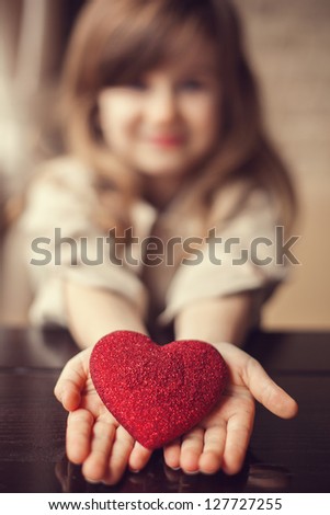 Valentine's Day - dreaming cute child with red Heart in hands. Series of photos