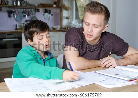 Older brother is helping his little brother with his maths homework