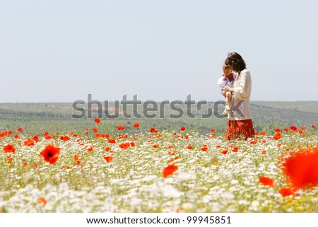 mother and son in traditional clothes in flower field