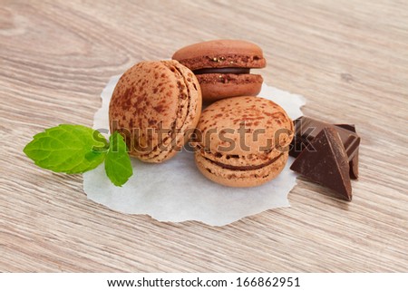 chacolate macaroons withfresh chocolate bar on table - stock photo