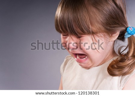 Portrait of a little girl. She is crying
