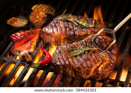 Beef steaks on the grill with flames